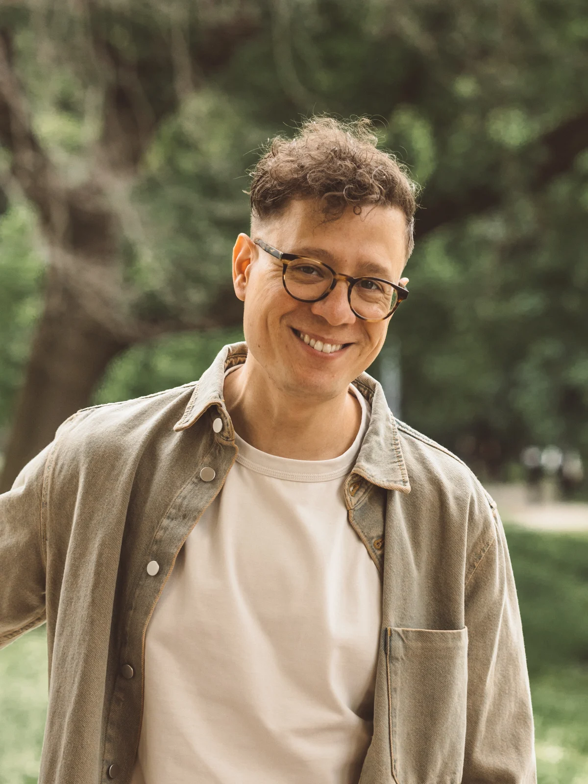Enrique Gabriel outdoors under the trees, smiling at the camera